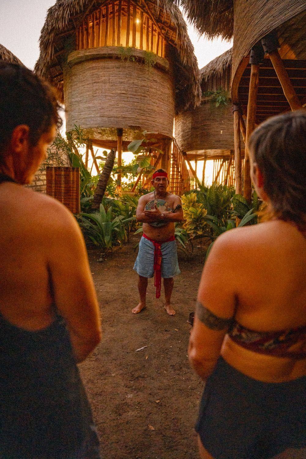 Guests gathered around a guide for a Mayan blessing at dusk
