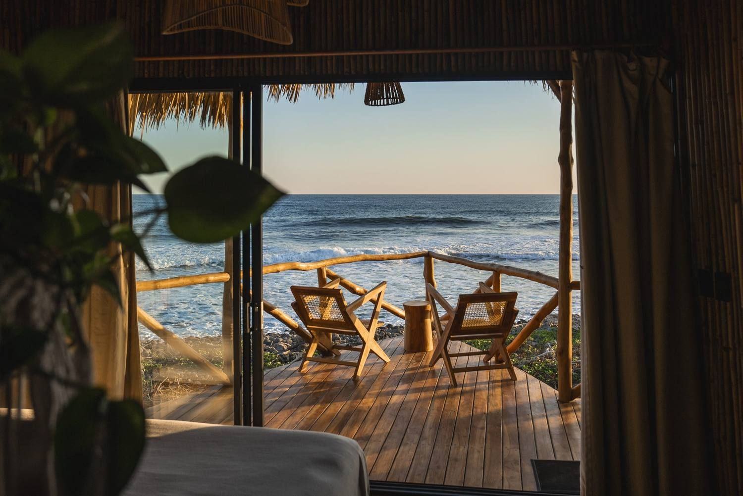 An open treehouse deck at Mizata looking out over the Pacific at golden hour