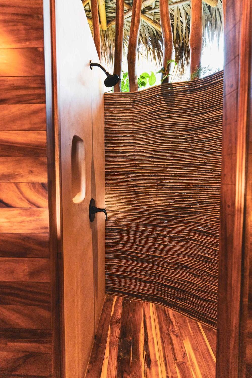 An open-air shower walled in woven reed