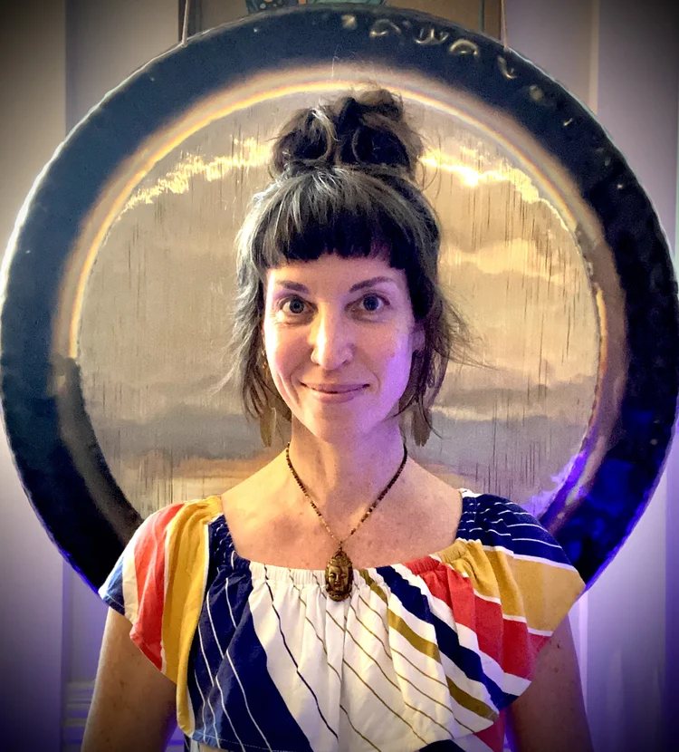 Monica Mullen smiling in front of a gong