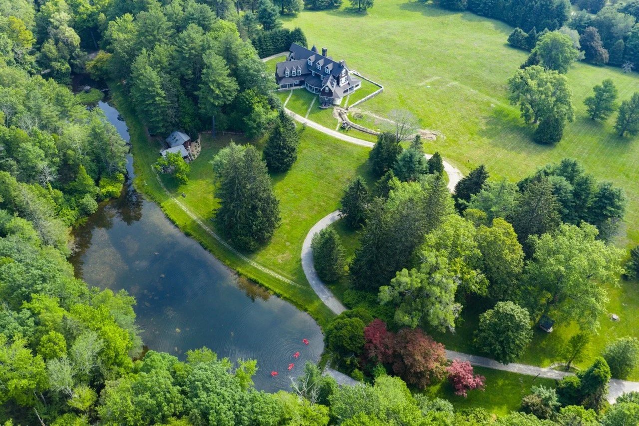 Aerial view of The Thyme: a pond, meadows and the Mountain House among the trees